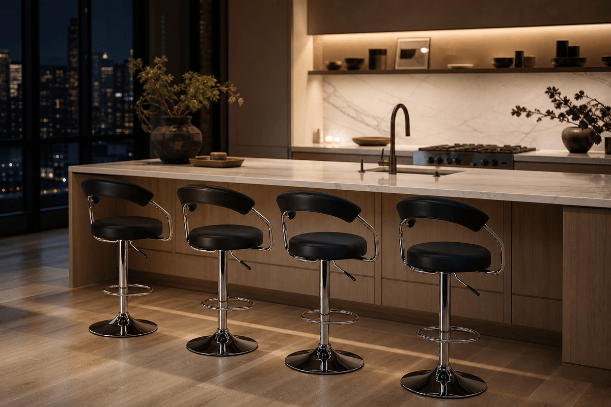 Four modern bar stools with black leather seats and chrome bases arranged in a row in front of a light wood kitchen island with a white marble countertop, set in a contemporary kitchen at night.