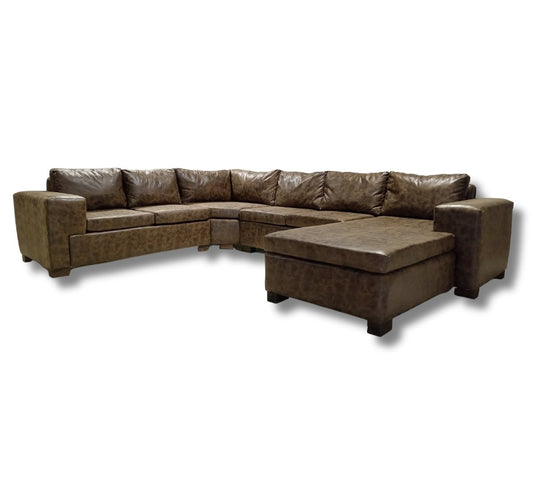 A brown Elephant Corner Couch with a chaise and ottoman, presented in a L-shaped configuration.