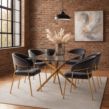 A modern 7-piece dining set featuring a rectangular glass-top table with a gold-tone X base and six matching velvet dining chairs with dark gray upholstery and gold legs, styled in a dining room with a brick wall and hanging pendant light.