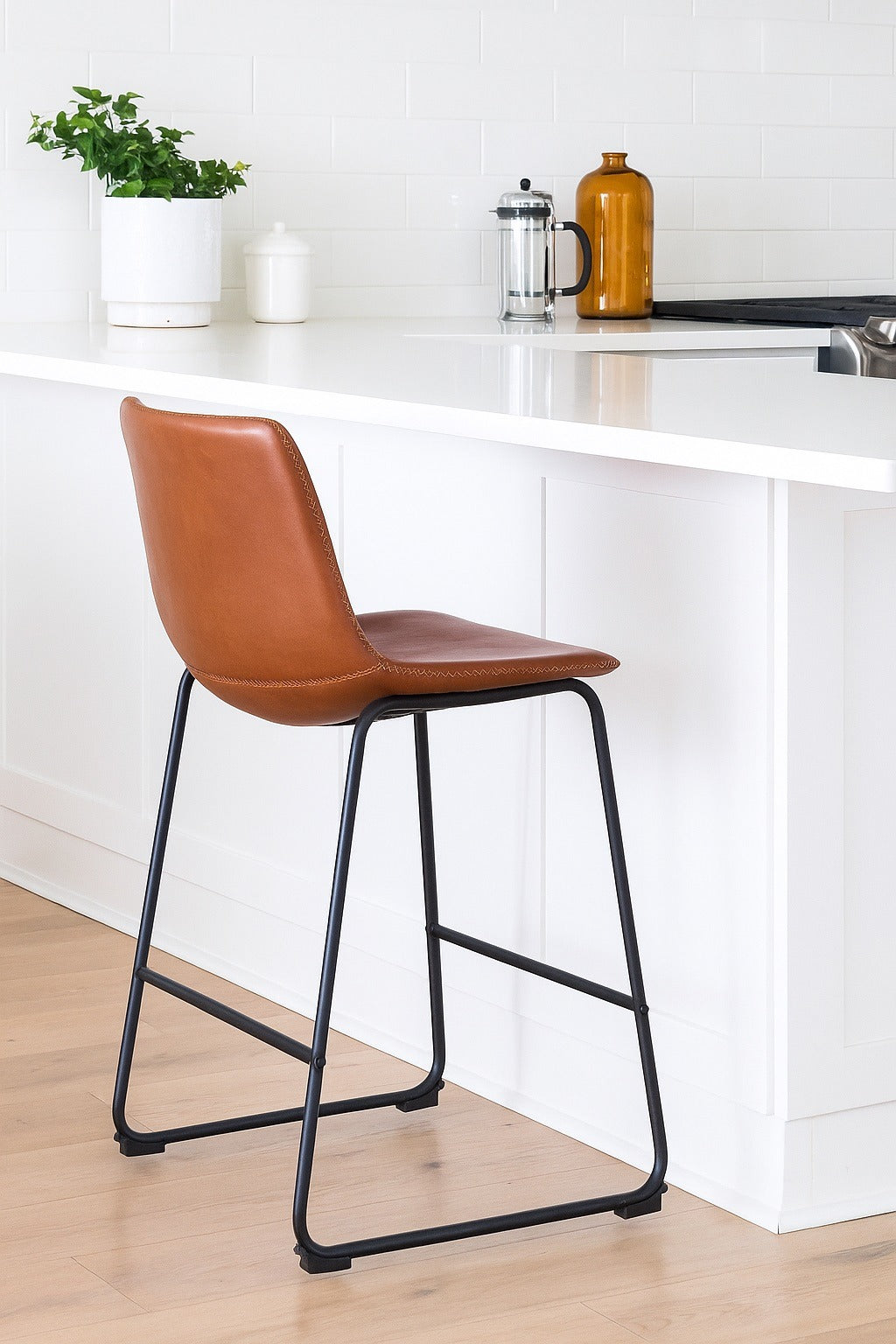 Brown bar stool with black legs in a kitchen setting