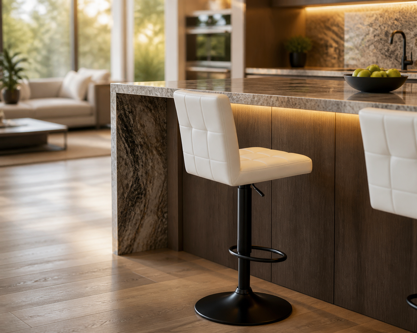 A modern kitchen island with a white tufted bar stool in the foreground, set in a bright, contemporary kitchen with wood flooring and marble countertops.