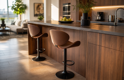 Two modern bar stools with brown upholstered seats and black metal bases, positioned at a kitchen island in a bright, contemporary kitchen.