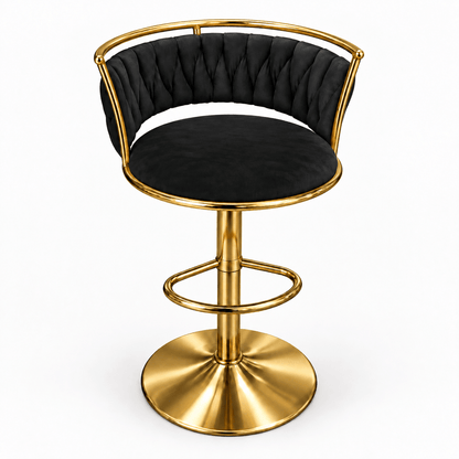A modern swivel bar stool with a black tufted velvet seat and backrest, supported by a polished gold-finished metal frame with a circular footrest and round pedestal base, shown on a plain white background.