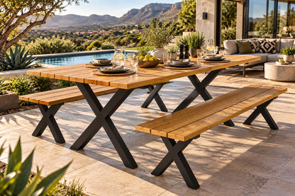 Outdoor dining set with a rectangular wooden table and two matching benches on a patio, set against a scenic mountain background with a pool and house visible.