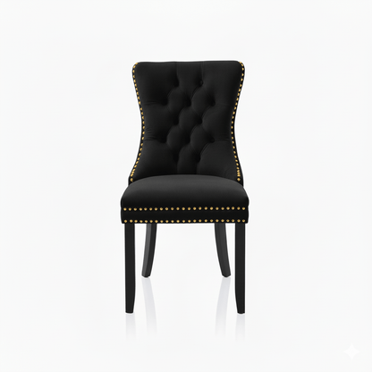 Black upholstered chair with gold nailhead trim on a white background