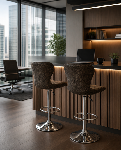 Two modern bar stools with textured brown fabric seats and chrome metal bases, positioned in front of a slatted wood counter in a contemporary office setting.