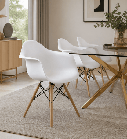 Three modern white molded plastic dining chairs with light wood legs and black cross-members, arranged around a glass-top dining table in a bright, contemporary room.