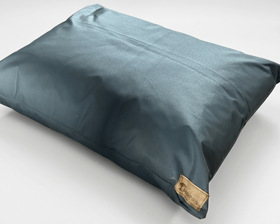 Blue pillow with a brand label on a light gray background