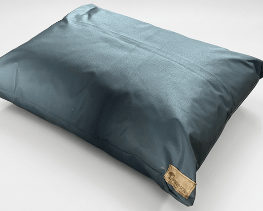Blue pillow with a brand label on a light gray background