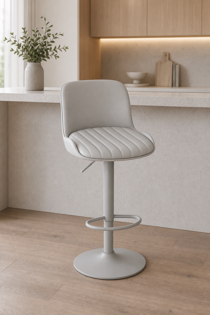 Adjustable chair with a rim for feet at  white counter and back support and padded seating.