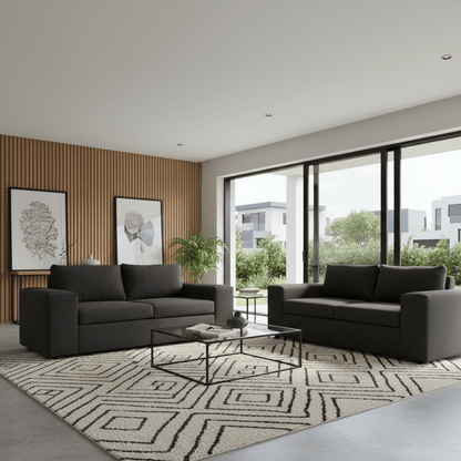 Modern living room with two dark gray two seater sofas, a coffee table, and decorative elements. The Couch Place