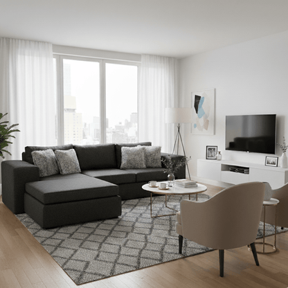 Modern living room with a black L shape corner couch sectional sofa, beige chairs, and a TV. That Couch Place