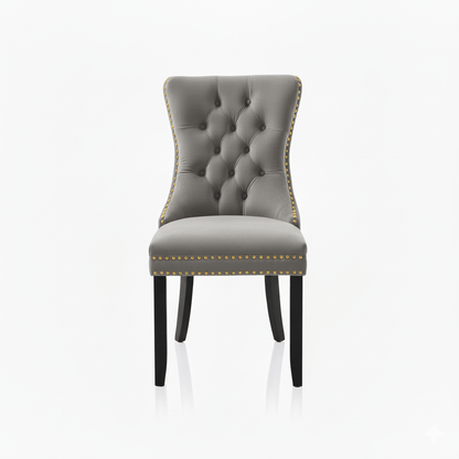 Gray upholstered chair with tufted backrest and nailhead trim on a white background