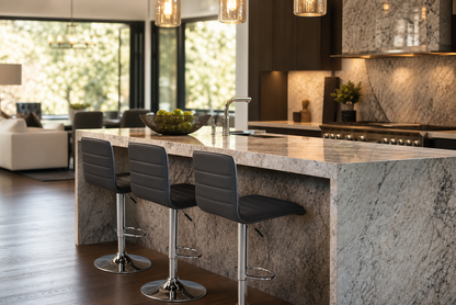 A modern kitchen island with a large gray and white marble countertop and matching marble base, paired with three dark gray bar stools with chrome bases. The kitchen features dark wood cabinetry, a stone backsplash, and pendant lights.