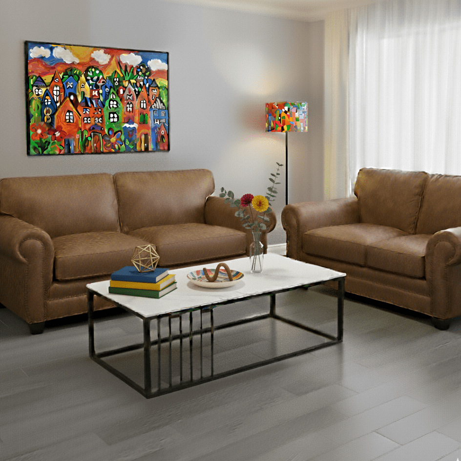Living room with soft brown sofas, a white coffee table, and colorful artwork on the walls.- That Couch Place
