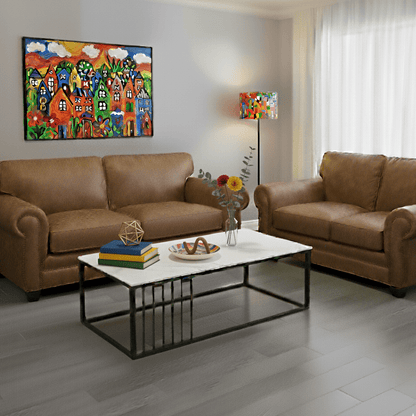 Living room with soft brown sofas, a white coffee table, and colorful artwork on the walls.- That Couch Place