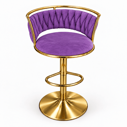 A modern bar stool with a tufted purple velvet seat and backrest, supported by a polished gold-finished metal frame and circular pedestal base, shown on a plain white background.