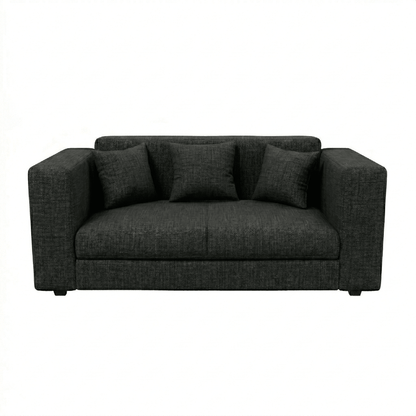 Dark gray sofa with three cushions on a white background