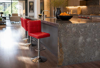Three red upholstered bar stools with chrome pedestal bases lined up along a dark stone kitchen island in a modern kitchen interior.