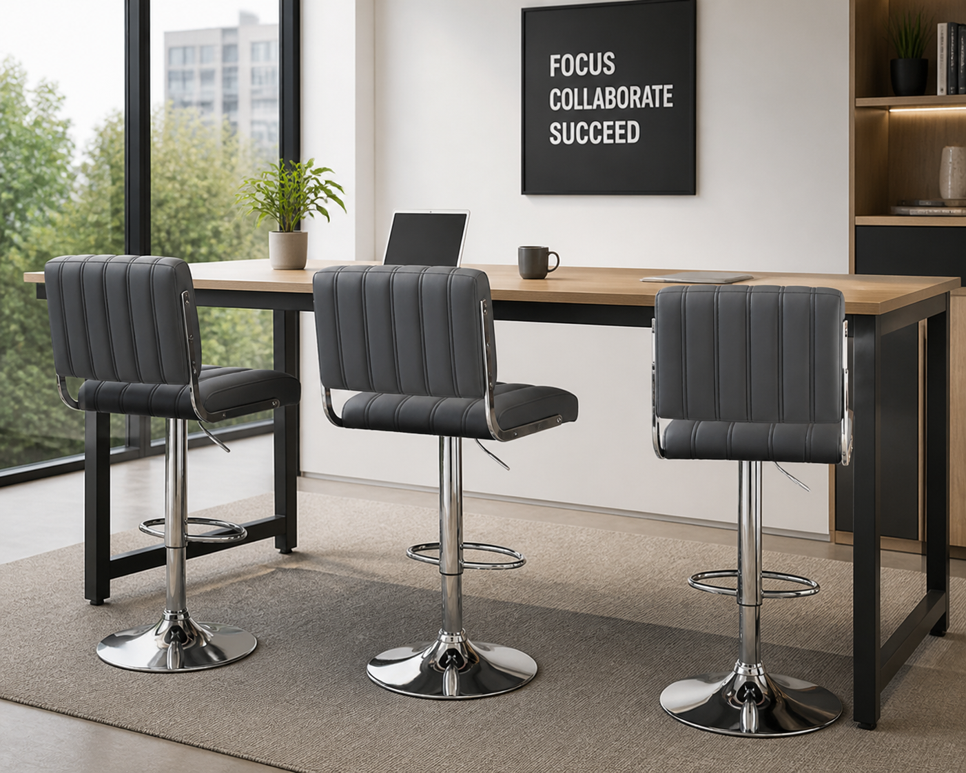 Three gray upholstered swivel bar stools with chrome pedestal bases arranged around a wooden-topped high table in a modern office setting.