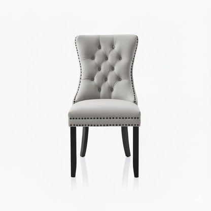 Beige upholstered chair with buttoned backrest and nail head trim on a white background
