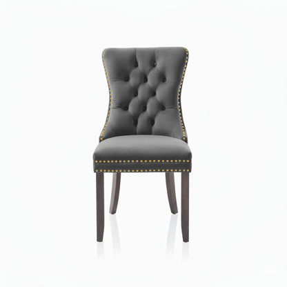 Gray upholstered chair with tufted backrest and gold nailed trim on a white background