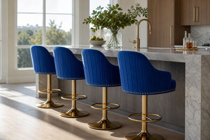 Four blue velvet bar stools with gold bases arranged around a marble kitchen island in a bright modern kitchen.