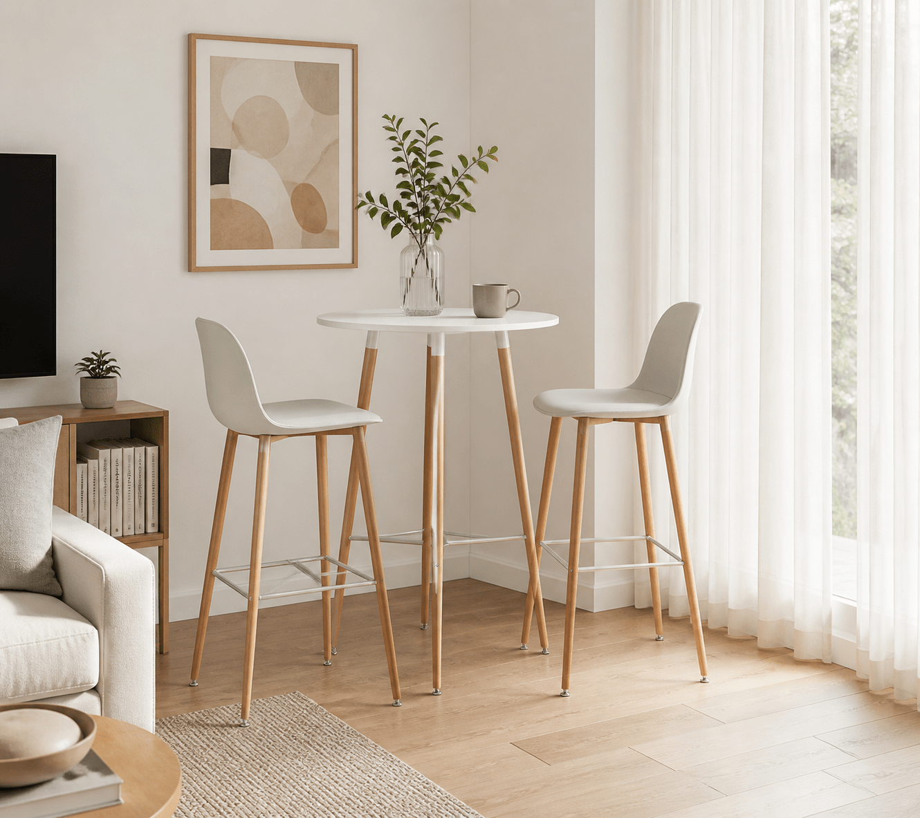 A small round white bar-height table with two light gray upholstered stools and natural wood legs, styled in a bright, modern living room corner.