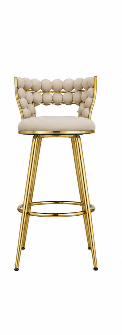 A modern bar stool with a tufted cream upholstered seat and backrest, supported by a polished gold metal frame and four legs.